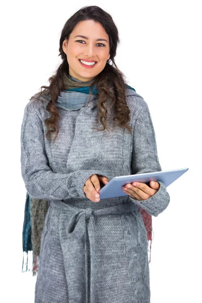 Modelo sonriente con ropa de invierno sosteniendo su tableta — Foto de Stock