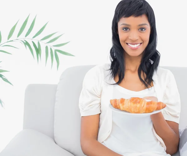 Encantadora mujer de pelo negro con ropa blanca sosteniendo un croissant —  Fotos de Stock