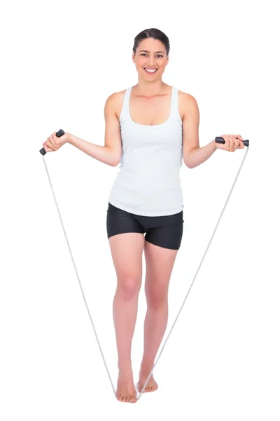 Smiling slender model jumping rope — Stock Photo, Image