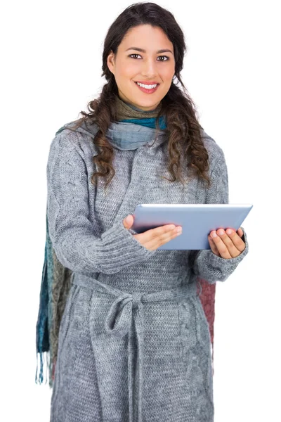 Alegre guapa morena vistiendo ropa de invierno sosteniendo su tablet — Foto de Stock