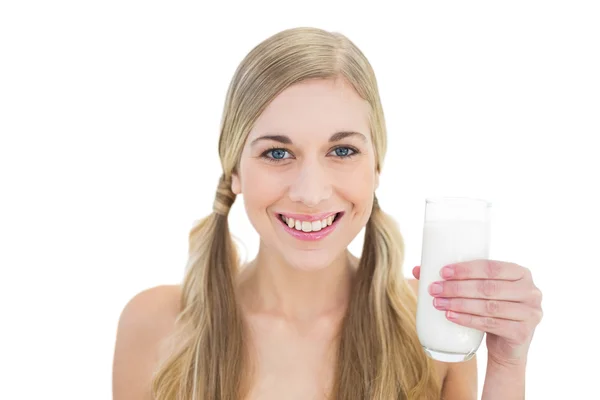 Delighted young blonde woman holding a glass of milk — Stock Photo, Image