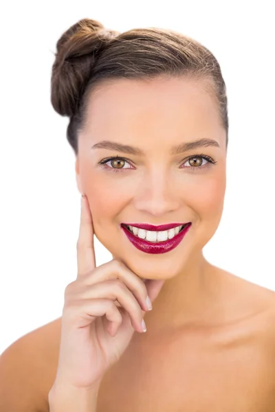 Mujer bonita con labios rojos tocando su mejilla sonriendo a la cámara — Foto de Stock