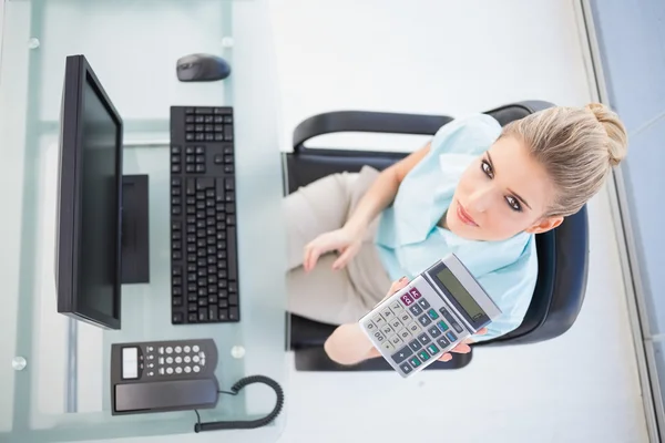 Overhead view of elegant businesswoman showing calculator — Stock Photo, Image
