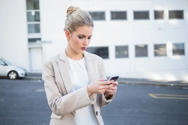 Fruncir el ceño elegante mujer de negocios enviando un texto —  Fotos de Stock