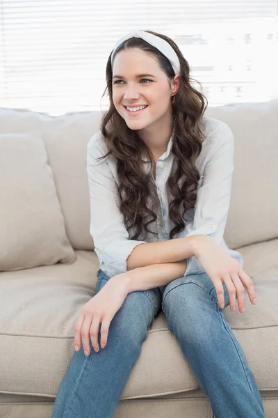Casual pretty woman sitting on a cosy couch — Stock Photo, Image