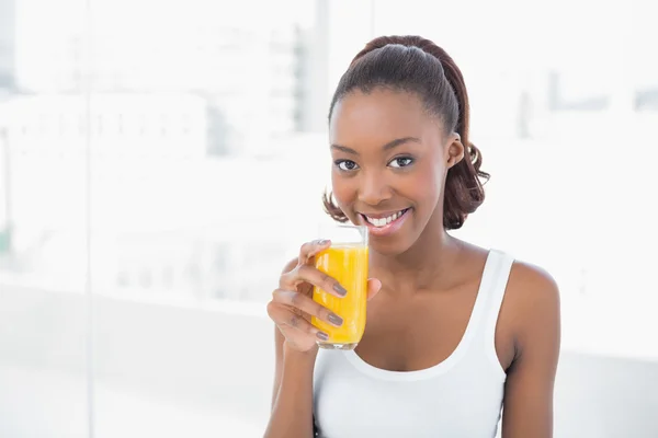 Modelo deportivo feliz sosteniendo vaso de jugo de naranja —  Fotos de Stock