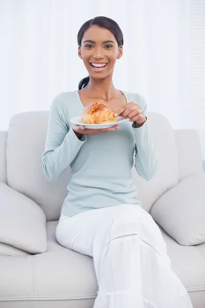 クロワッサンを食べることの魅力的な女性の笑みを浮かべてください。 — ストック写真