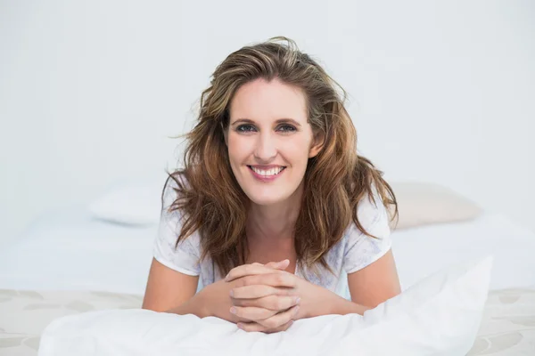 Portret van lachende vrouw liggend op bed — Stockfoto