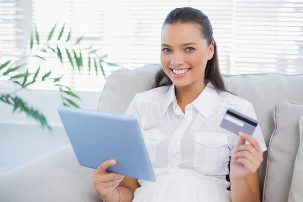 Улыбающаяся симпатичная женщина, покупающая онлайн с помощью планшетного компьютера — стоковое фото
