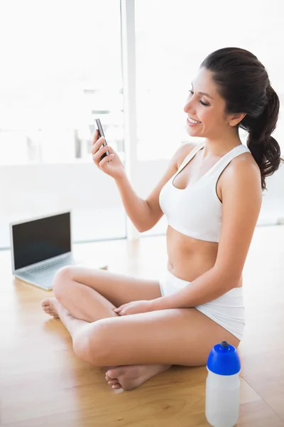 Ajuste mujer enviando un mensaje de texto con smartphone —  Fotos de Stock