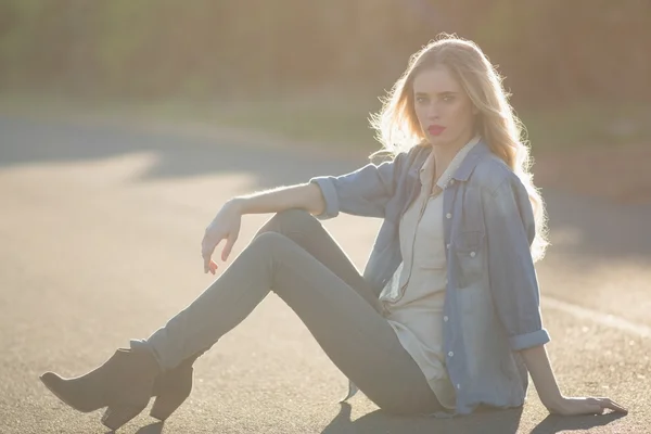 Aantrekkelijke vrouw zitten op weg — Stockfoto