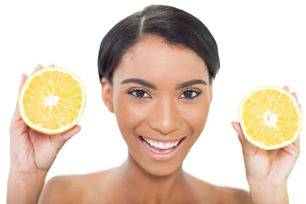 Modelo atraente natural segurando fatias de laranja em ambas as mãos — Fotografia de Stock