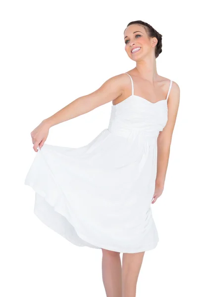 Smiling beautiful young model in white dress dancing — Stock Photo, Image