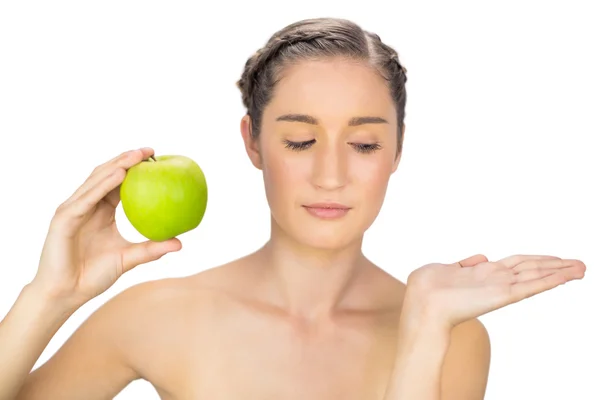 Serious healthy model holding green apple — Stock Photo, Image