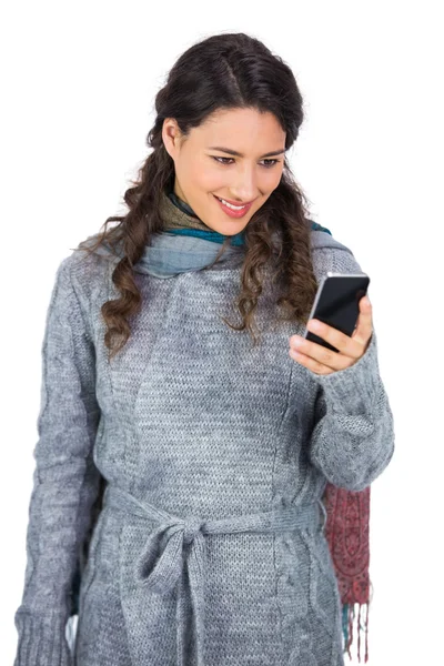 Morena bonita usando roupas de inverno segurando seu smartphone — Fotografia de Stock