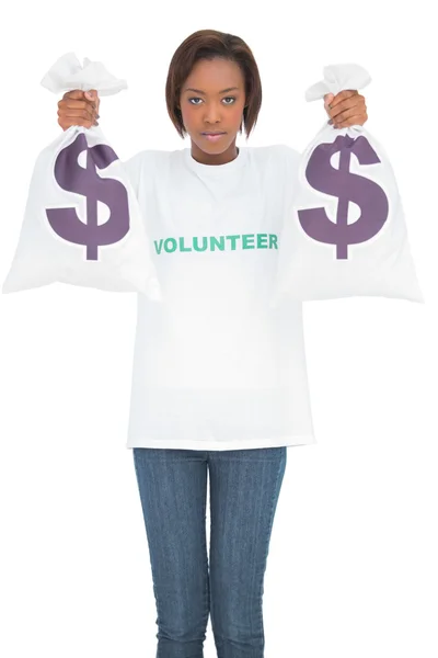 Serious volunteer woman holding money bags — Stock Photo, Image