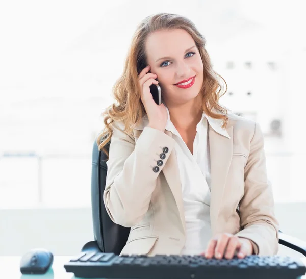 Pleased pretty businesswoman answering a phone call — Stock Photo, Image