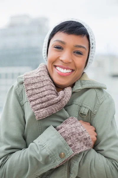 Delighted young model in winter clothes closing her jacket — Stock Photo, Image