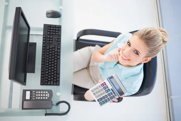 Overhead view of cheerful businesswoman showing calculator — Stock Photo, Image