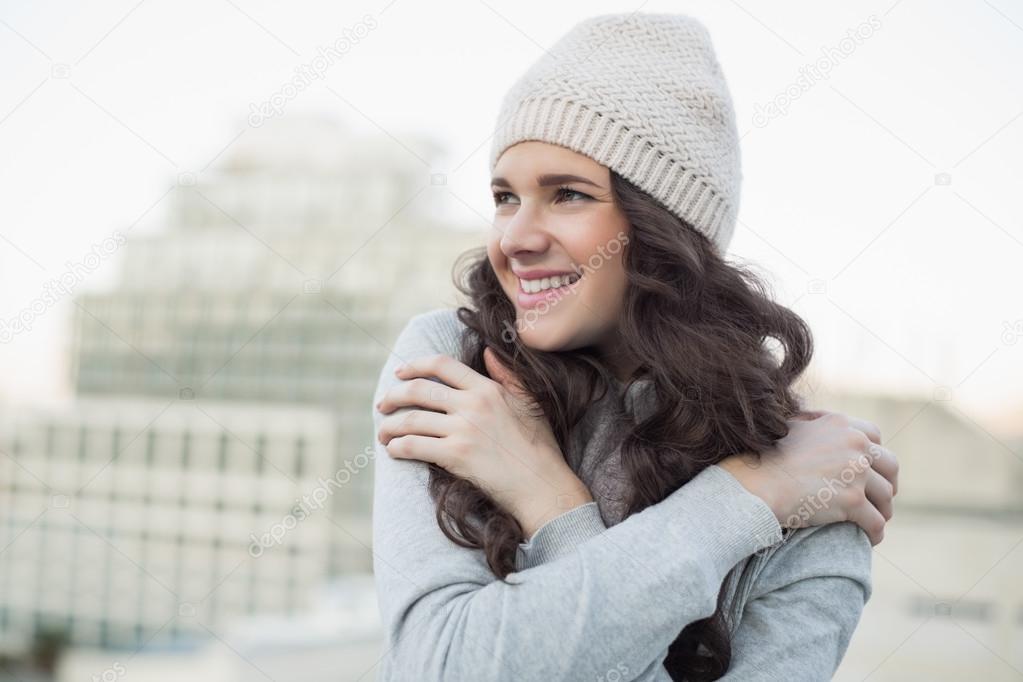 Smiling pretty young brunette shivering