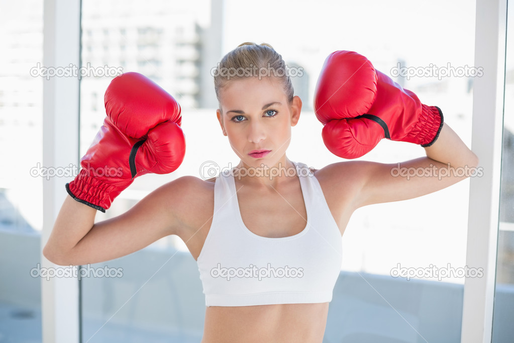 Dynamic young blonde model wearing boxing gloves
