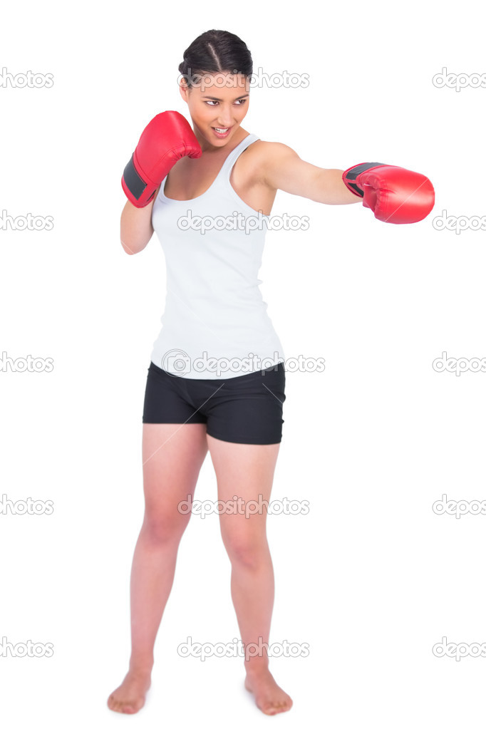 Smiling slender model with boxing gloves punching