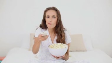 kase mısır yatakta yeme ve tv seyretmek genç kadın