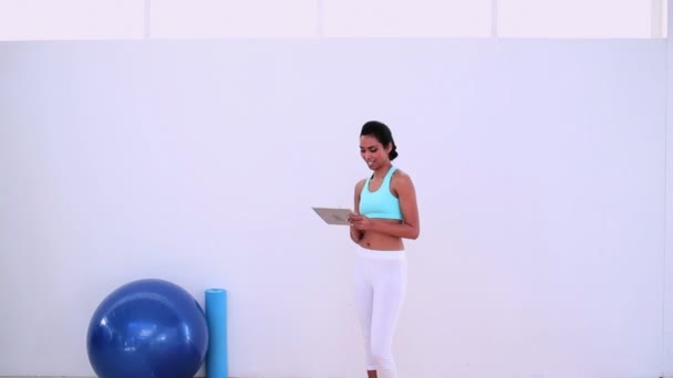 Fit woman using her digital tablet standing — Stock Video