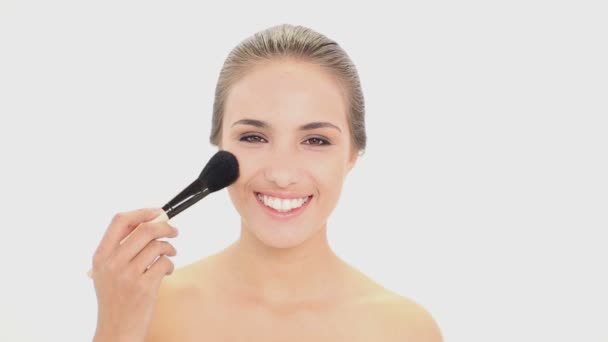 Hermosa modelo usando un cepillo de polvo en su cara — Vídeos de Stock