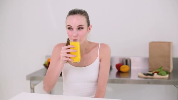 Leende modell dricka glas apelsinjuice — Stockvideo