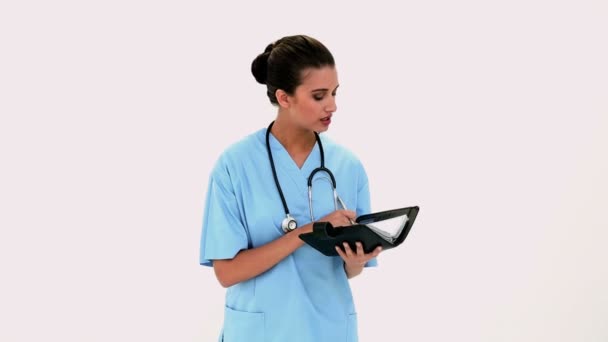 Pensive beautiful nurse checking a schedule — Stock Video