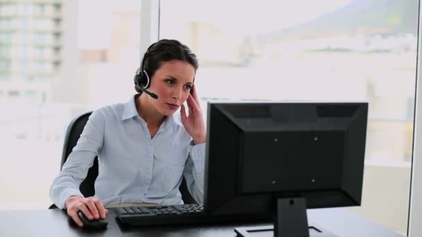 Call center agent na volání u svého psacího stolu — Stock video