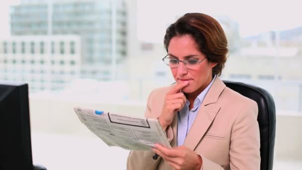 Concentrated attractive businesswoman reading a newspaper — Stock Video