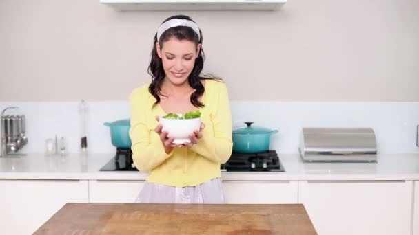 Hermosa morena recogiendo un tazón de ensalada — Vídeos de Stock