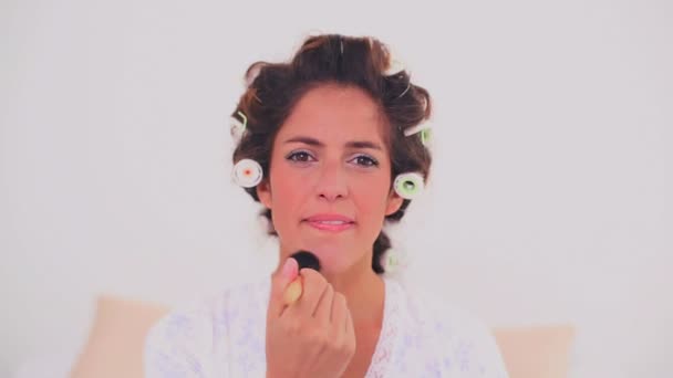 Contenuto donna in bigodini per capelli applicando polvere — Video Stock