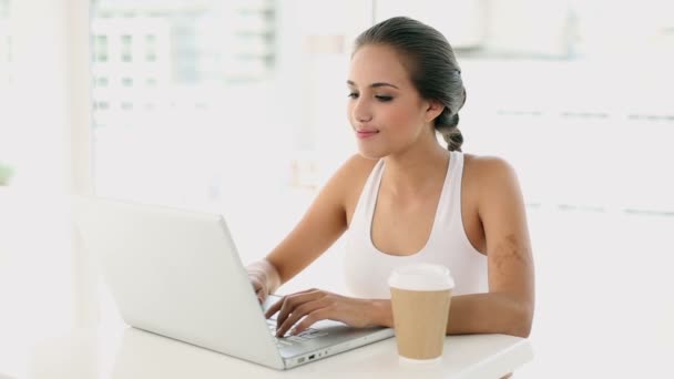 Hermosa mujer joven usando su computadora portátil — Vídeo de stock