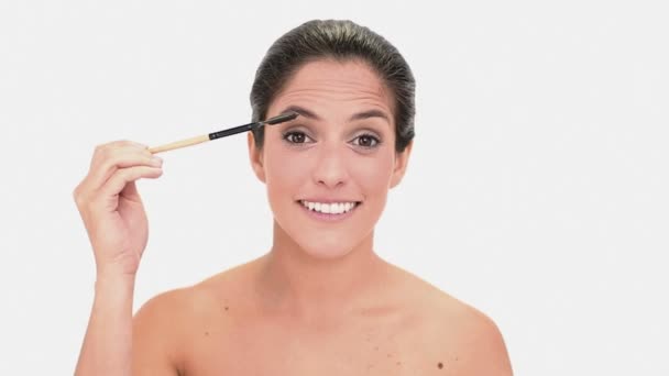 Konzentrierte brünette Frau streicht sich die Augenbrauen — Stockvideo