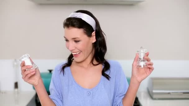 Beautiful brunette holding two salt cellars — Stock Video