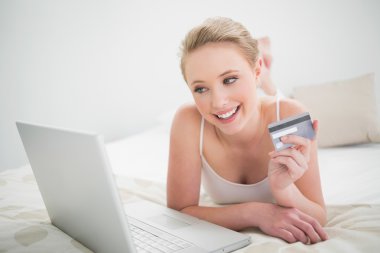 doğal sarışın holding kredi kartı gülümseyerek ve laptop arıyorum