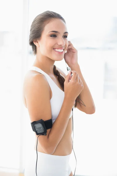 Sporty brunette listening to music — Stock Photo, Image