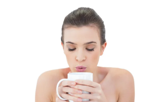Peaceful model blowing on her coffee — Stock Photo, Image