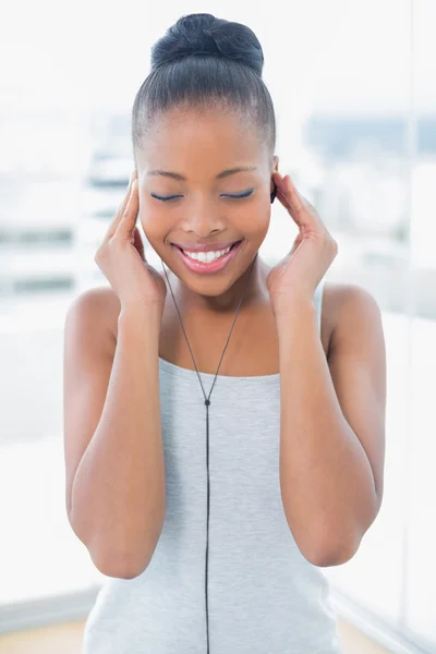 Peaceful woman in sportswear listening to music — Stock Photo, Image