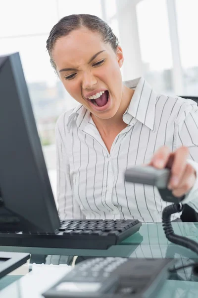 Angry businesswoman screaming while hanging up the telephone — Stock Photo, Image