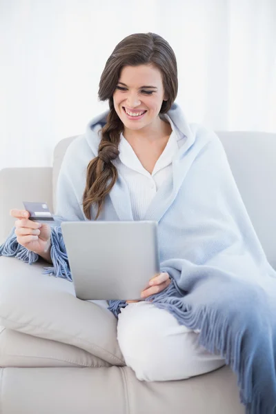Симпатичная женщина в белом пижаме делает покупки в интернете со своим планшетным компьютером — стоковое фото
