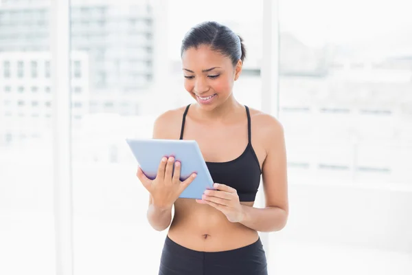Concentrated model in sportswear using a tablet pc — Stock Photo, Image