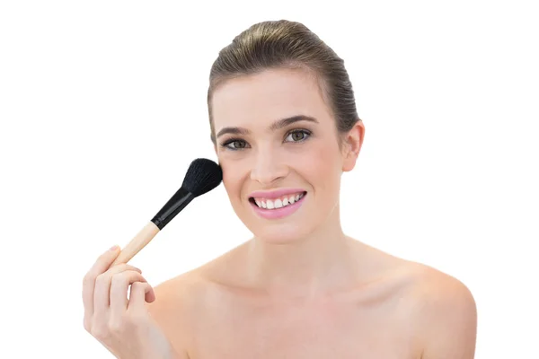 Cheerful model applying powder on her face — Stock Photo, Image