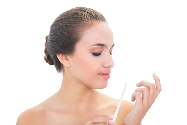 Young woman looking at her nail file — Stock Photo, Image