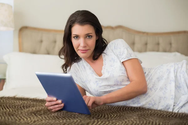 Mujer bonita grave usando una tableta pc — Foto de Stock