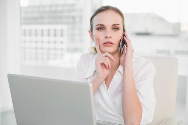 Mujer de negocios reflexivo uso de la computadora portátil y hacer una llamada —  Fotos de Stock