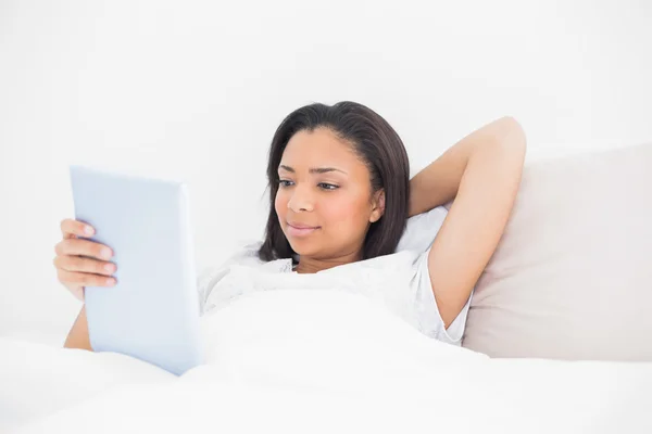 Modelo joven relajado usando una tableta pc — Foto de Stock